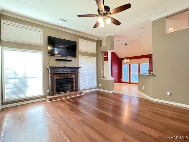 unfurnished living room featuring hardwood / wood-style flooring, ornamental molding, and plenty of natural light