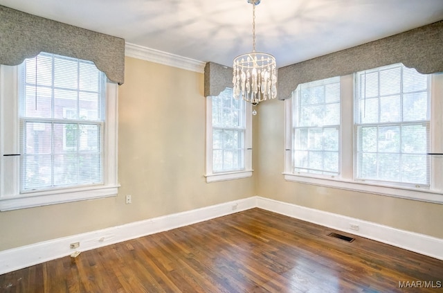 unfurnished dining area with crown molding, a notable chandelier, and hardwood / wood-style flooring