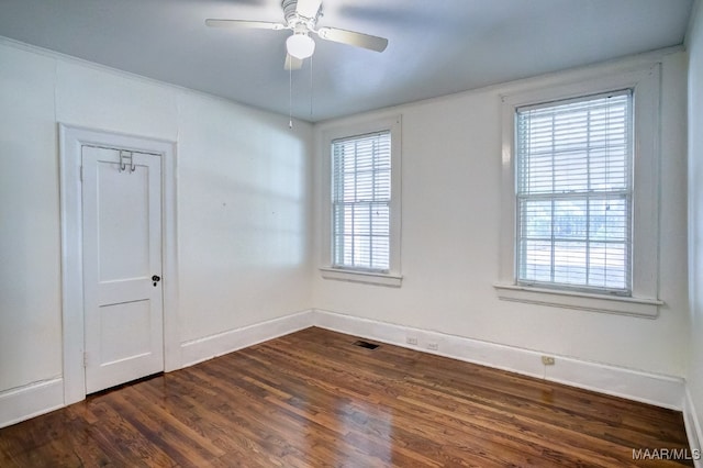 spare room with plenty of natural light, dark wood-type flooring, and ceiling fan