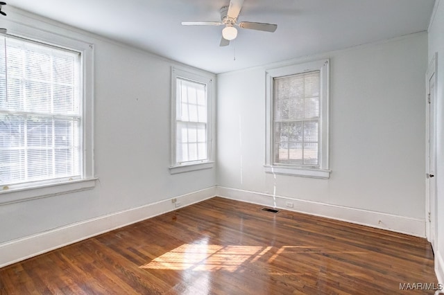 spare room with dark hardwood / wood-style flooring, ceiling fan, and plenty of natural light