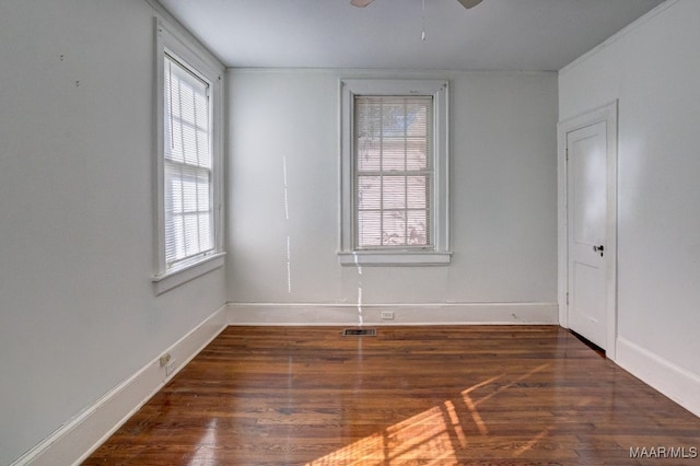 empty room with ceiling fan and dark hardwood / wood-style flooring