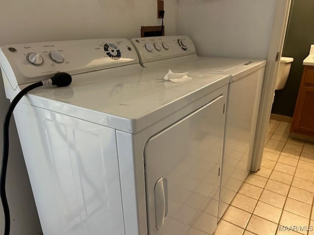 laundry area featuring light tile patterned floors and separate washer and dryer