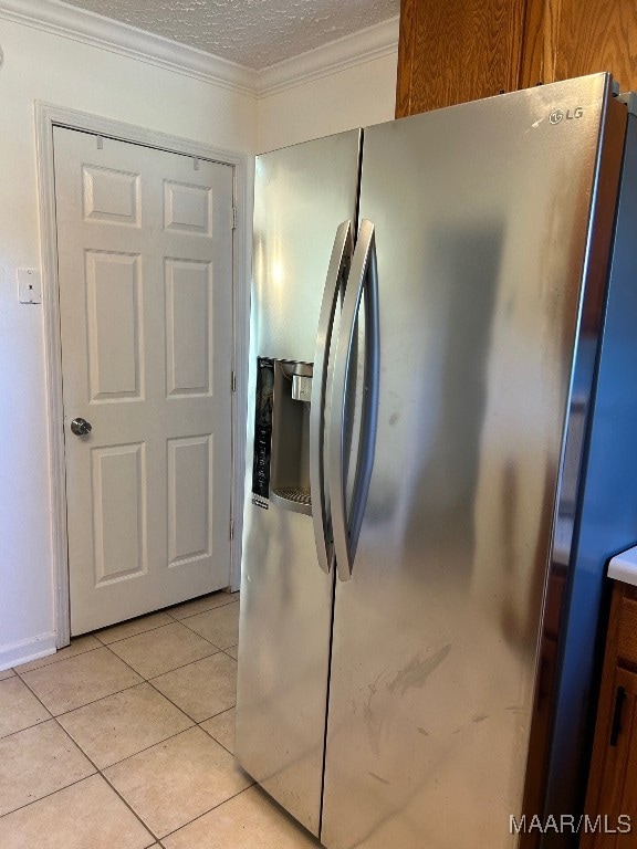 kitchen with a textured ceiling, light tile patterned flooring, crown molding, and stainless steel refrigerator with ice dispenser