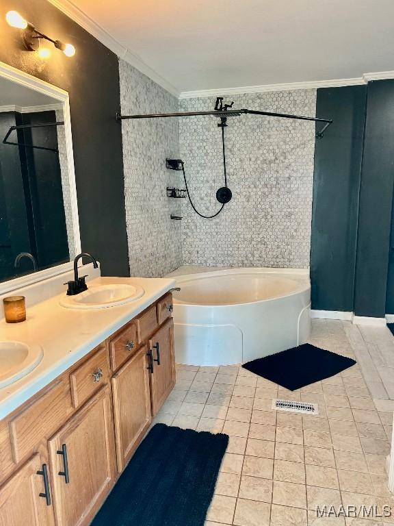 bathroom featuring a bathing tub, vanity, crown molding, and tile patterned floors