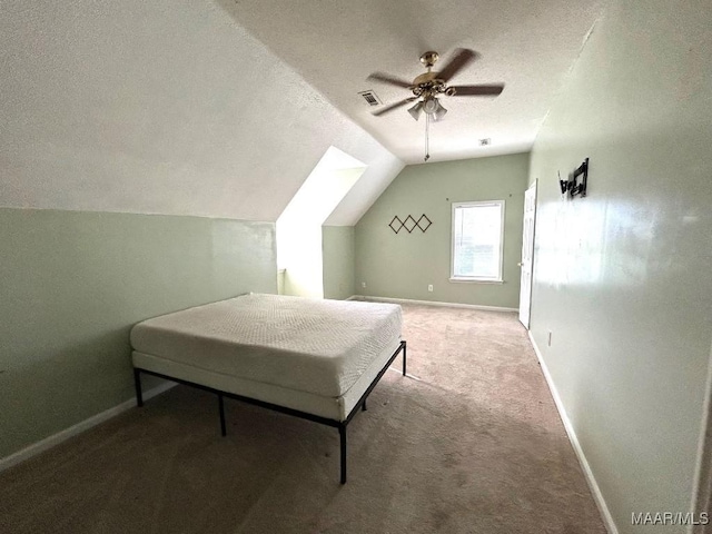 bedroom with carpet flooring, ceiling fan, a textured ceiling, and lofted ceiling