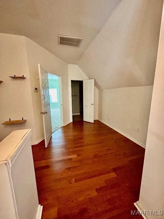 additional living space featuring dark hardwood / wood-style flooring and vaulted ceiling