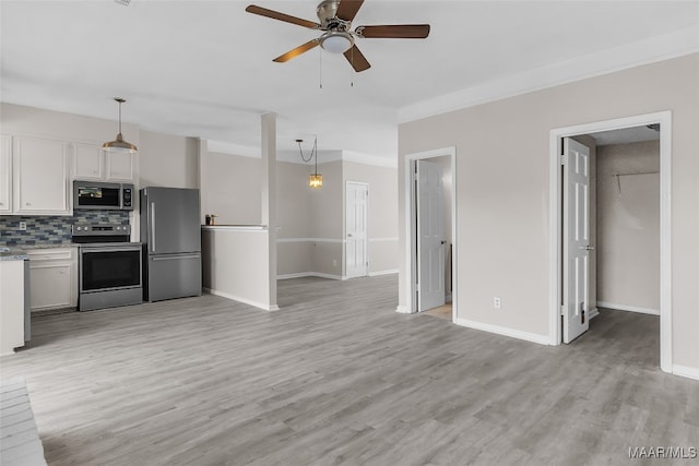 kitchen featuring white cabinetry, light hardwood / wood-style flooring, backsplash, pendant lighting, and appliances with stainless steel finishes