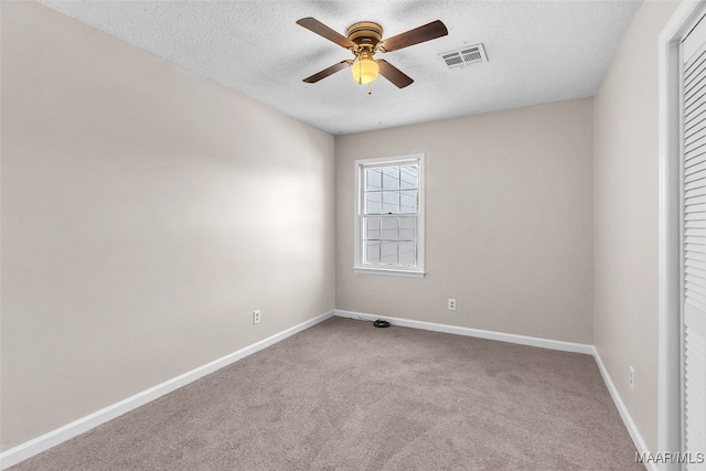 unfurnished room with carpet, ceiling fan, and a textured ceiling