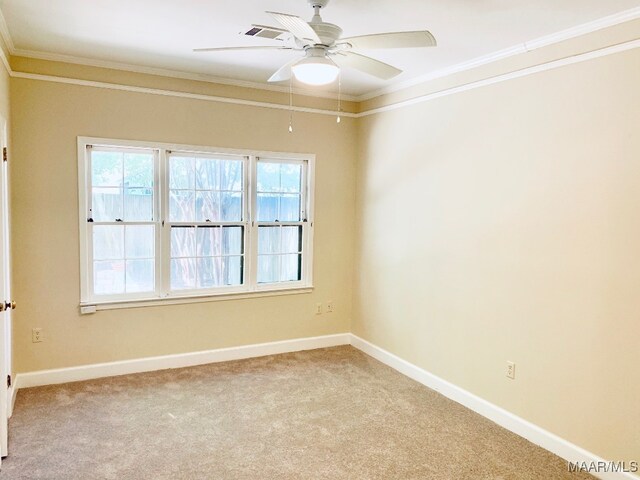 spare room with crown molding, ceiling fan, and light colored carpet