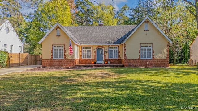 english style home featuring a front yard