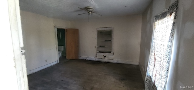 empty room featuring ceiling fan and dark wood-type flooring