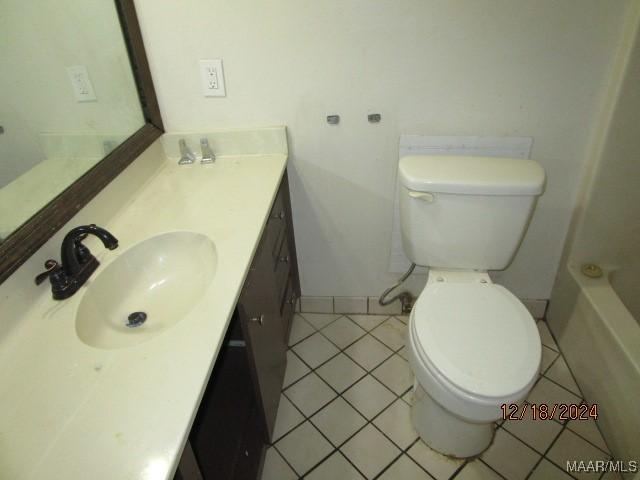 bathroom with tile patterned flooring, vanity, and toilet