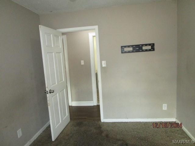 carpeted empty room featuring a textured ceiling