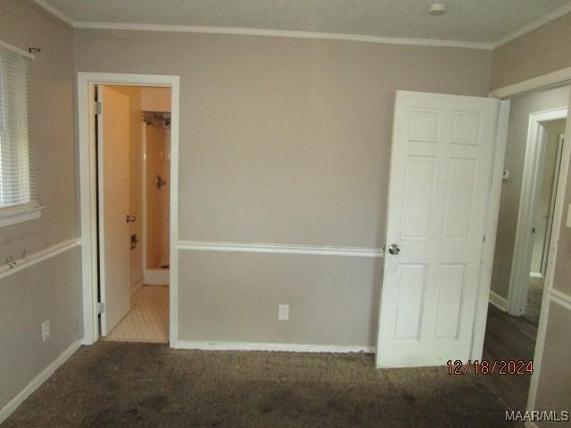 carpeted empty room featuring crown molding