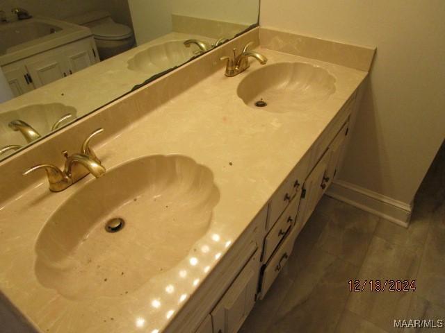 bathroom featuring tile patterned flooring, vanity, and toilet