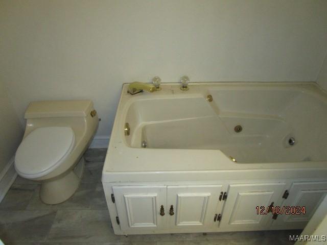 bathroom featuring toilet and a tub