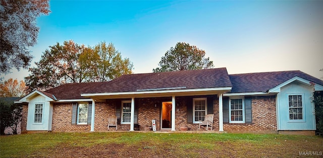 ranch-style house with a porch and a yard