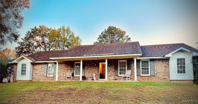 ranch-style home featuring a lawn and a porch