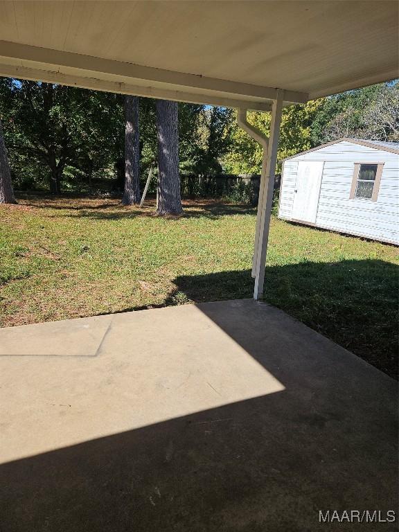 view of yard featuring a patio and a shed