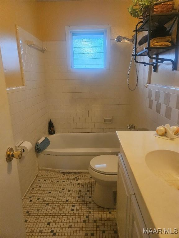 full bathroom featuring toilet, vanity, tile patterned floors, and tiled shower / bath combo