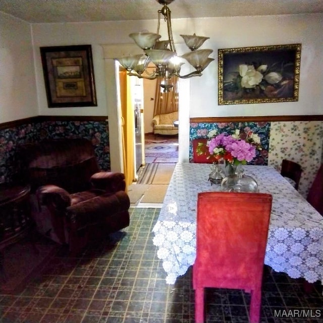 dining space featuring a textured ceiling and a notable chandelier