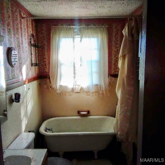 bathroom with a bath and a textured ceiling