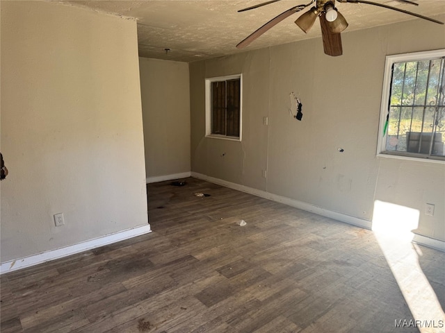 unfurnished room with ceiling fan, dark wood-type flooring, and a textured ceiling