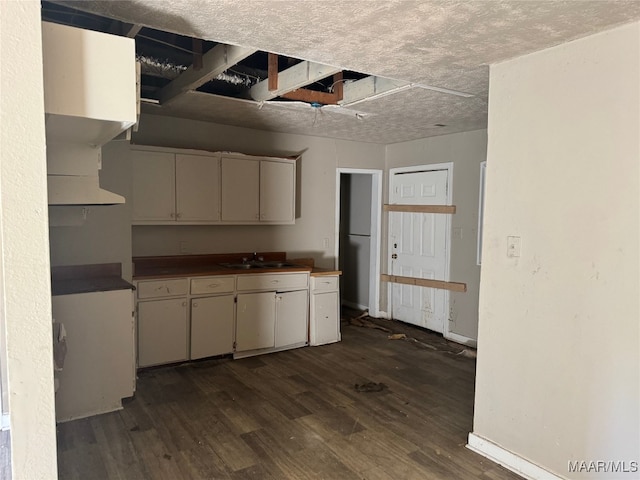 kitchen featuring a textured ceiling, dark hardwood / wood-style floors, and sink