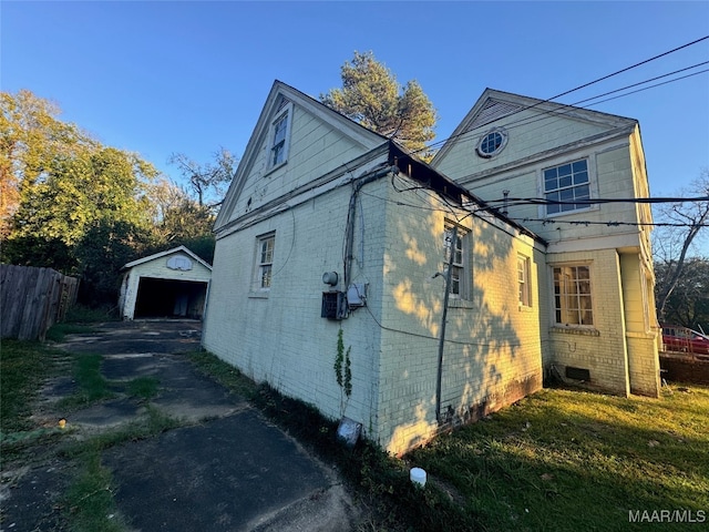 view of home's exterior featuring a garage, a yard, and an outbuilding