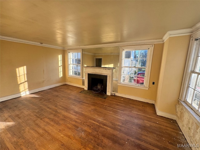 unfurnished living room with wood-type flooring, plenty of natural light, and ornamental molding