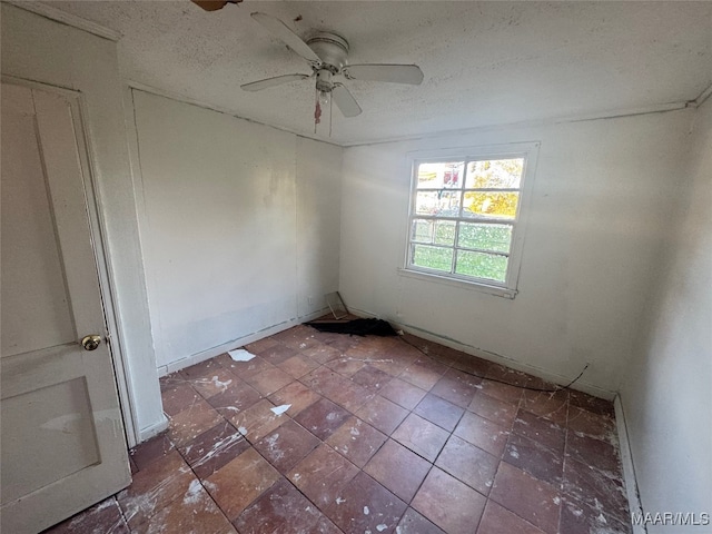 empty room featuring ceiling fan and a textured ceiling