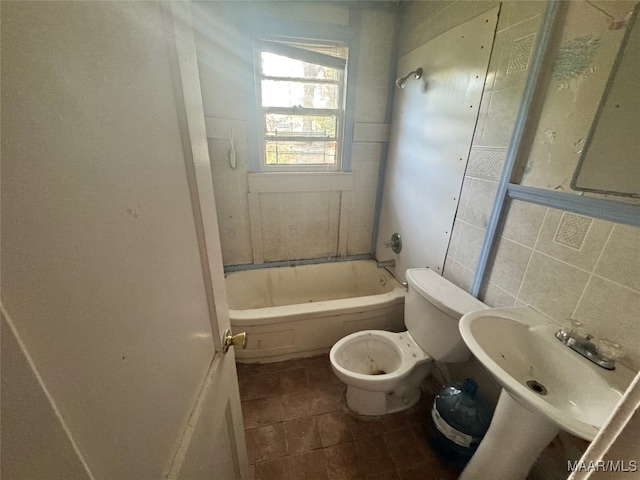 bathroom with tile patterned flooring, shower / bathing tub combination, tile walls, and toilet