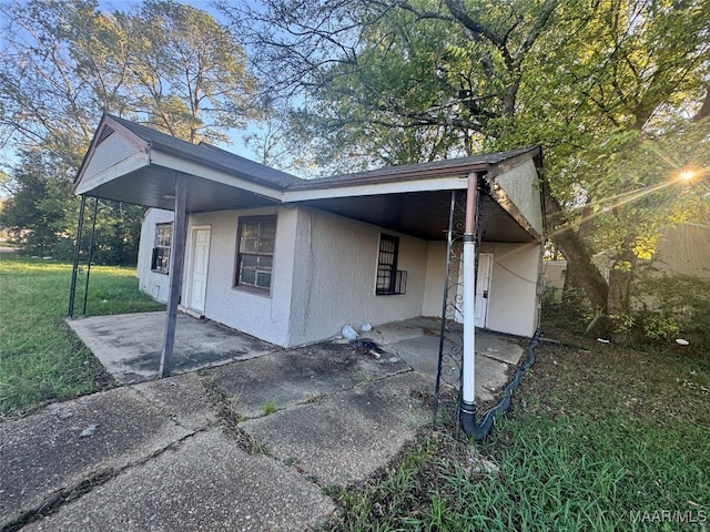 view of side of home featuring a carport and a lawn