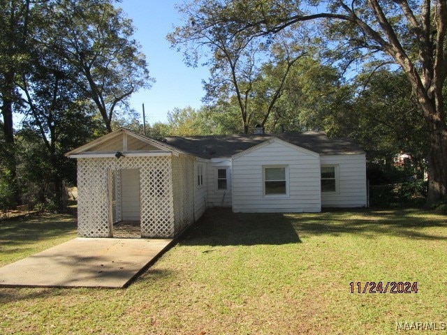 back of property featuring a lawn and a patio