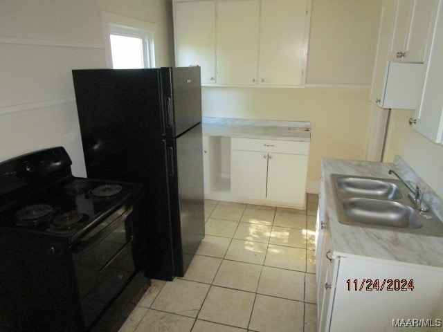 kitchen featuring white cabinets, light tile patterned floors, sink, and black appliances