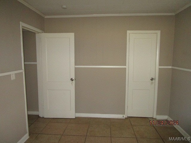 unfurnished bedroom featuring tile patterned flooring and ornamental molding