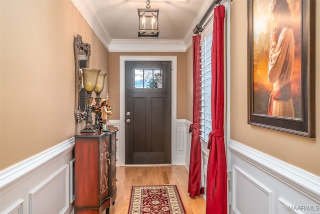 entryway featuring light hardwood / wood-style flooring, crown molding, and a notable chandelier