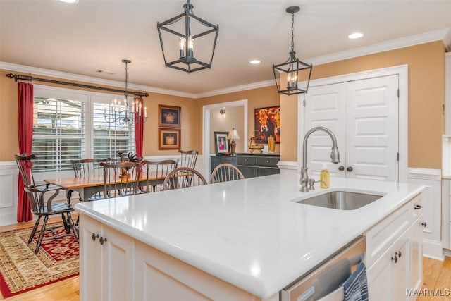 kitchen featuring a kitchen island with sink, sink, white cabinets, and light hardwood / wood-style flooring