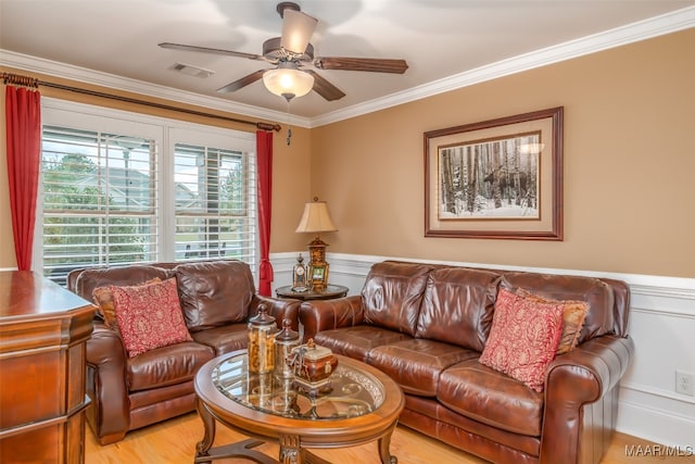 living room with crown molding, ceiling fan, and light hardwood / wood-style floors