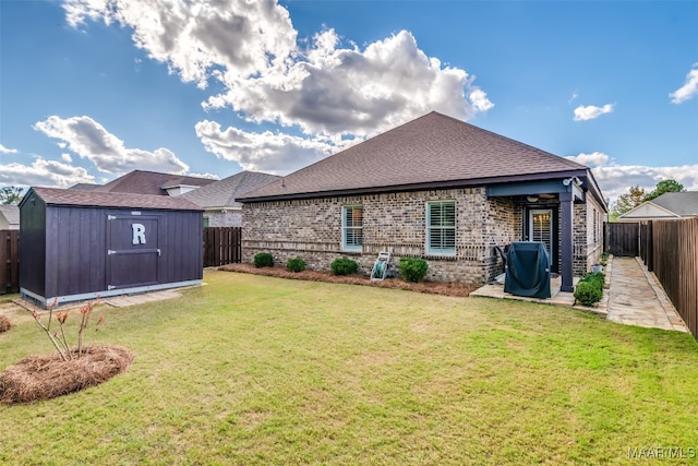 rear view of property with a lawn and a storage unit