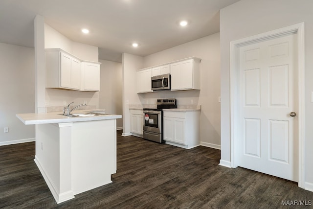 kitchen with white cabinetry, dark wood-type flooring, stainless steel appliances, and sink