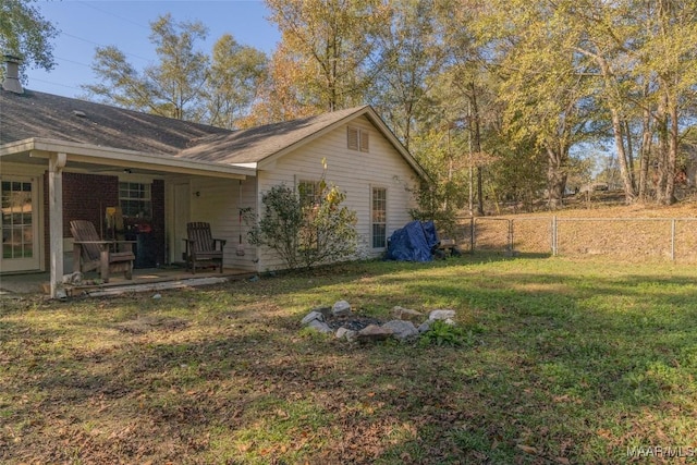 view of side of home featuring a lawn and fence