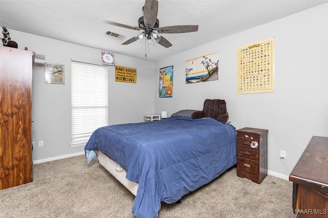 bedroom featuring carpet floors, baseboards, visible vents, and a textured ceiling