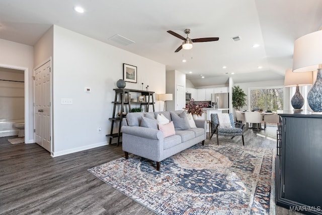 living room with dark hardwood / wood-style flooring, ceiling fan, and lofted ceiling