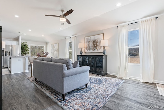 living room featuring ceiling fan, dark wood-type flooring, and vaulted ceiling