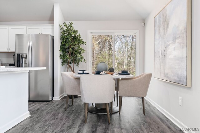 dining area with vaulted ceiling and dark hardwood / wood-style floors