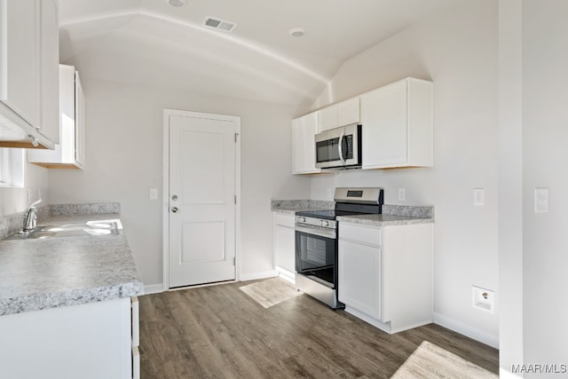 kitchen featuring white cabinetry, stainless steel appliances, dark hardwood / wood-style floors, lofted ceiling, and sink