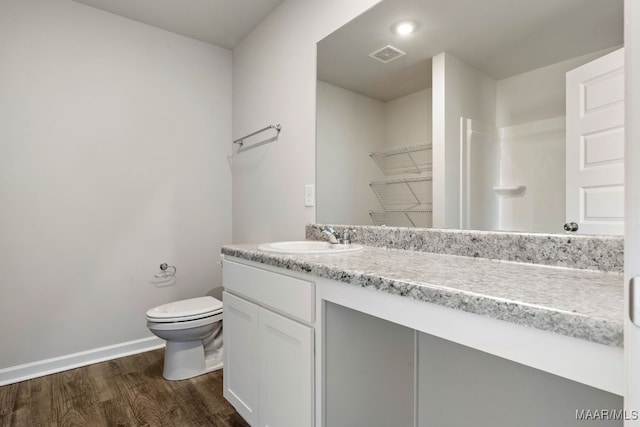 bathroom featuring toilet, vanity, and hardwood / wood-style floors