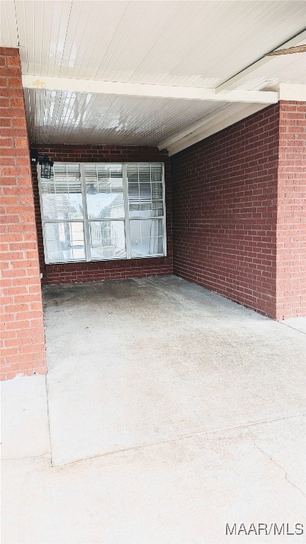 unfurnished room with brick wall