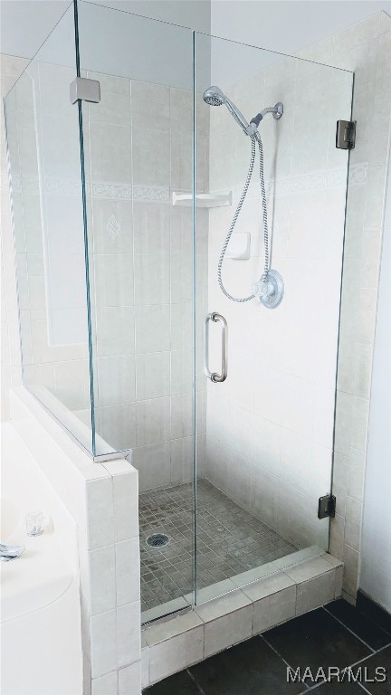 bathroom featuring tile patterned floors and a shower with shower door